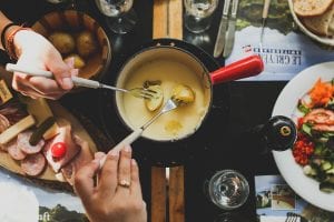 friends enjoying mozarella fondue in a pan