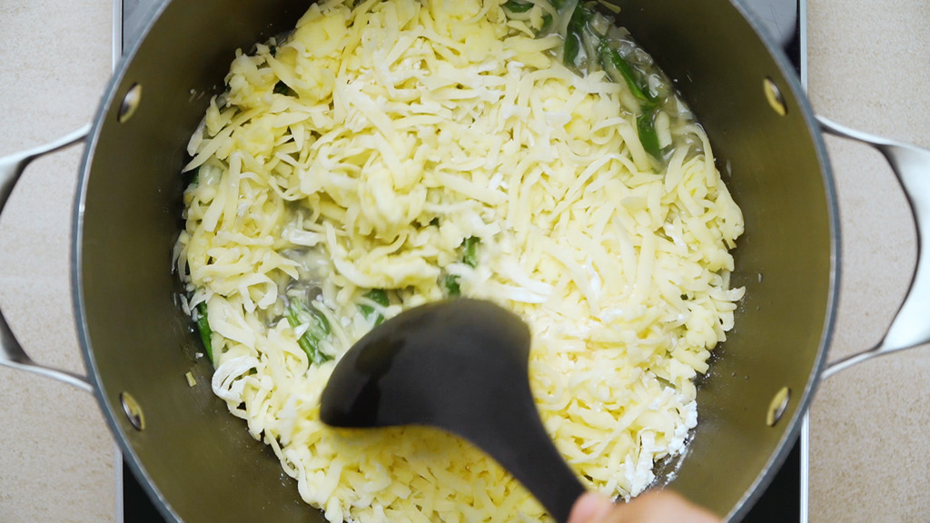 adding the coated cheese to the saucepan