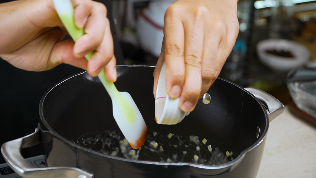 adding hot sauce to the saucepan