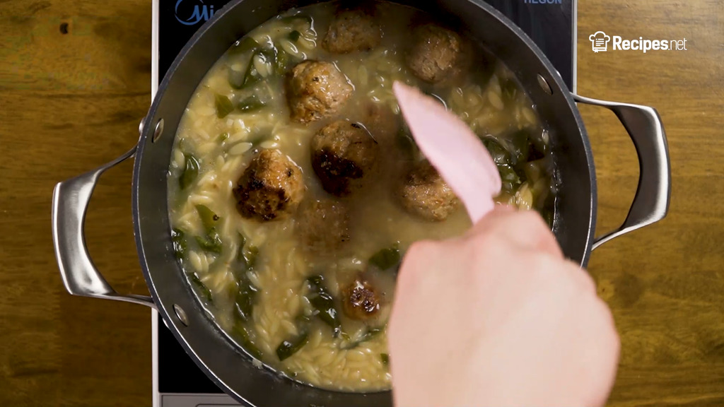 adding the meatballs to the soup