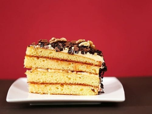 a slice of a 4-layer cake with frosting