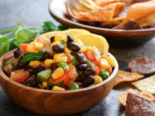 homemade black bean corn salsa with chips served in a wooden bowl