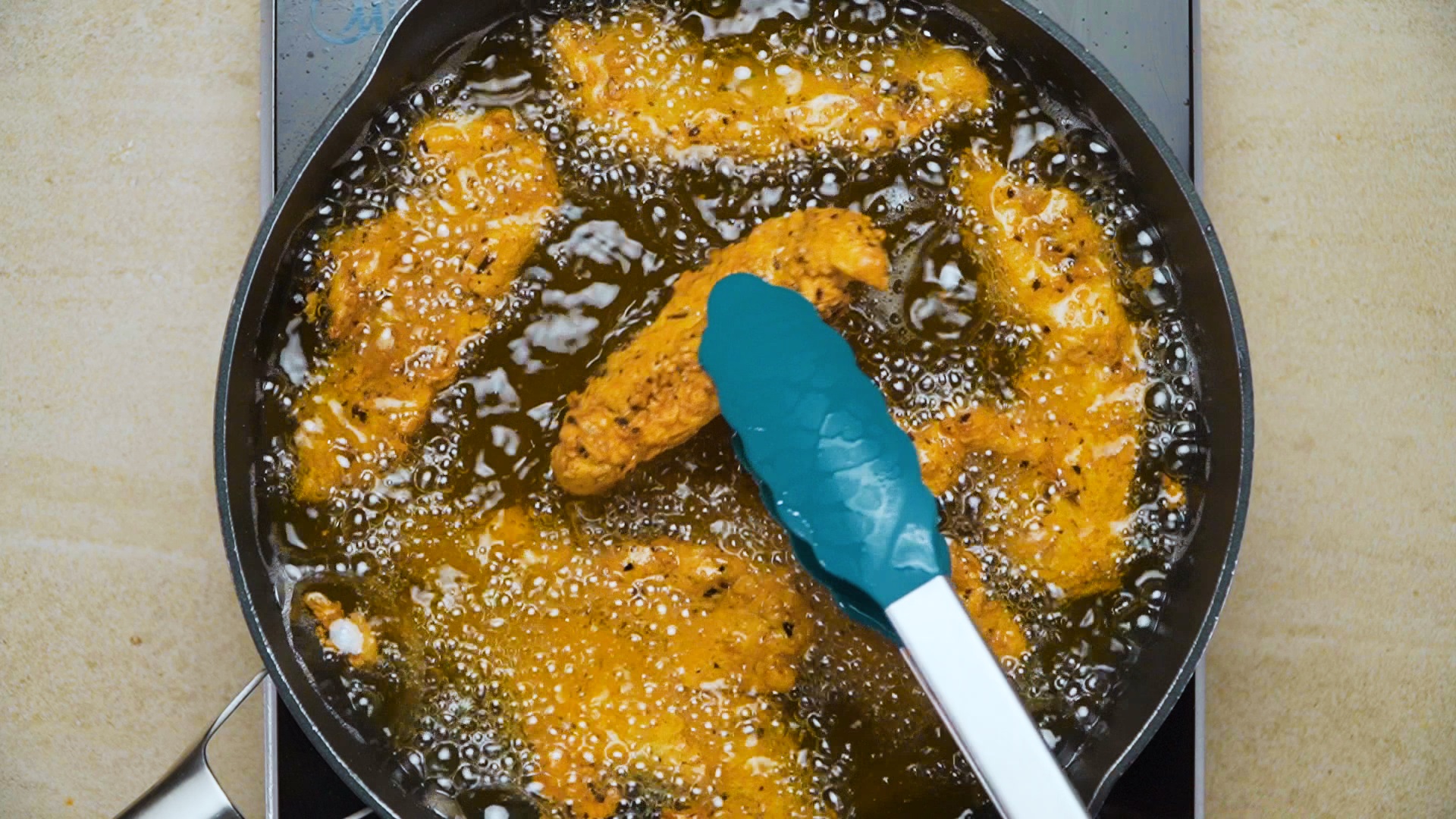 Chicken Strips Or Nuggets Being Deep-fried In A Cast-iron Frying