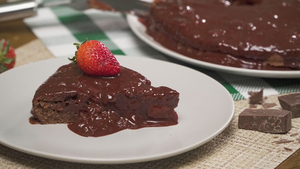 chocolate stawberry sauce covered cake with strawberry on top