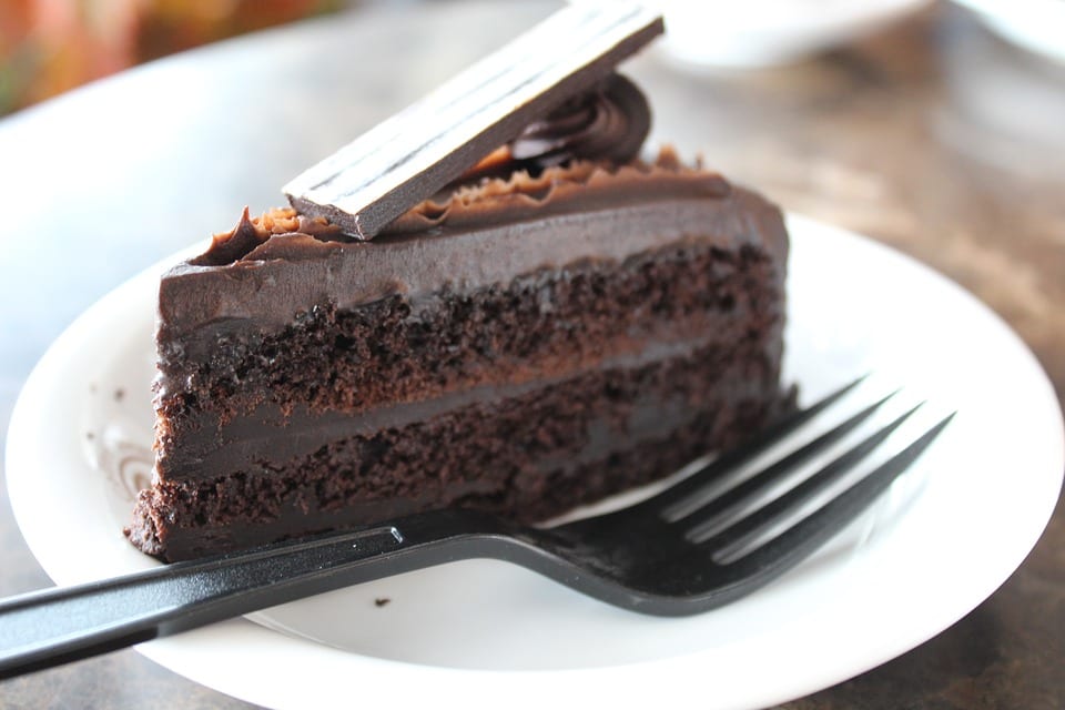 a slice of chocolate fudge cake with a fork on a plate