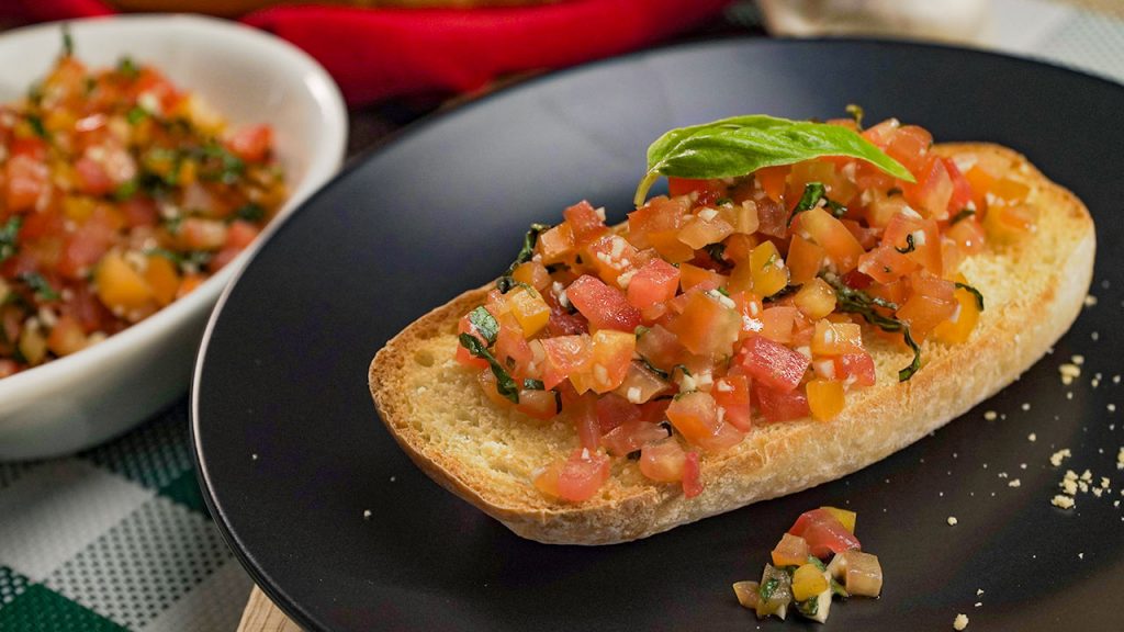 Copycat Olive Garden Bruschetta Recipe, Ciabatta bread topped with chopped tomatoes, garlic, and basil leaves