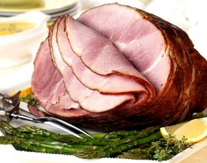 Dr. Pepper And Brown Sugar Glazed Crockpot Ham Recipe, Cut of pork ham with asparagus and a slice of lemon on the side
