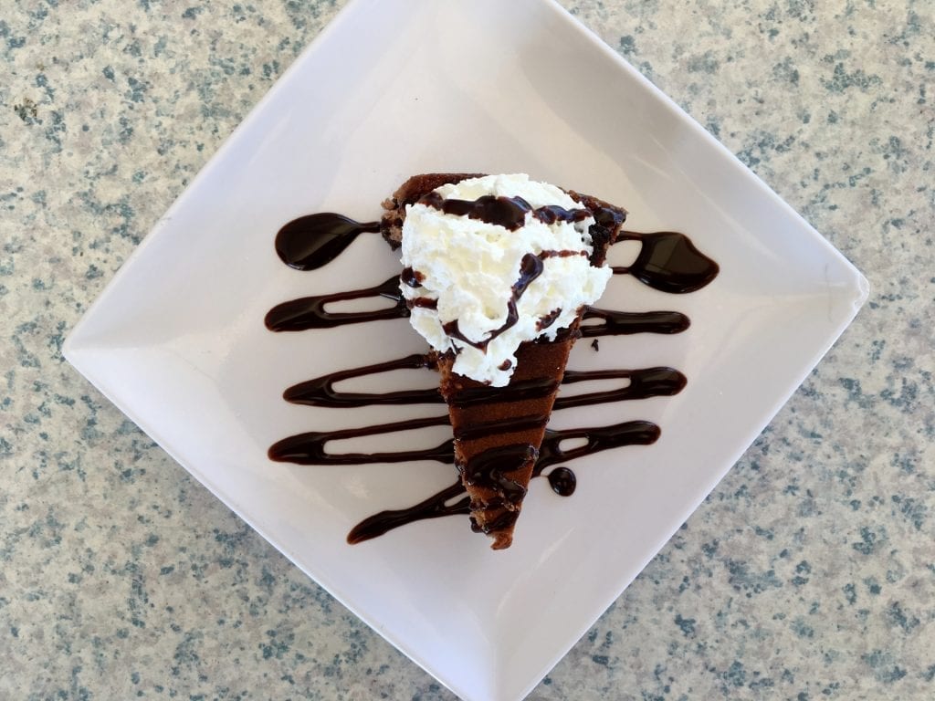 top view of a chocolate cheesecake topped with whipped cream