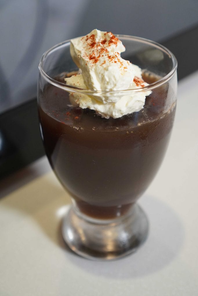 soda jelly in a glass with whipped cream and coffee granules on top