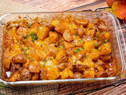 Spicy Roasted Potatoes Recipe, Roasted potatoes topped with melted cheddar cheese and chopped parsley is served on a baking casserole