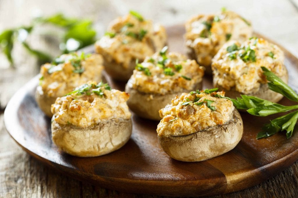 stuffed mushrooms on a wooden plate