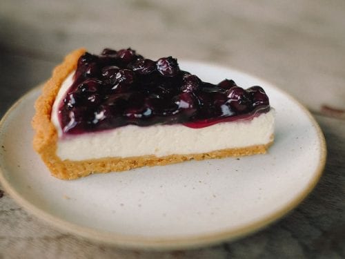 a slice of cheesecake pie topped with blueberry filling