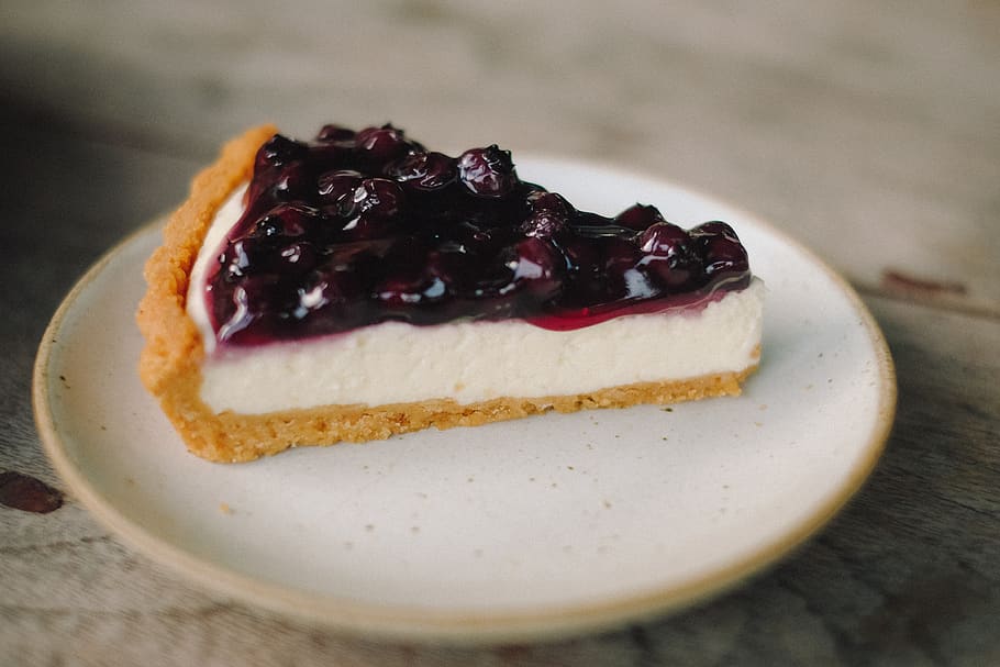 a slice of cheesecake pie topped with blueberry filling
