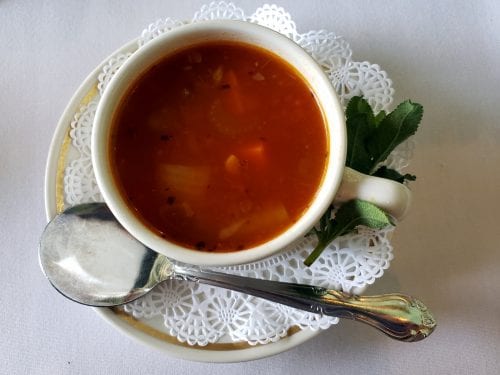 tomato-based vegetable soup in a white bowl