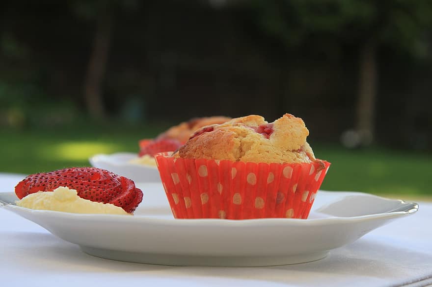 strawberry muffin with sliced strawberries on the side