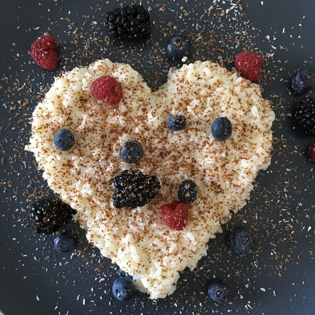 rice pudding in a heart shape and garnished with fruits