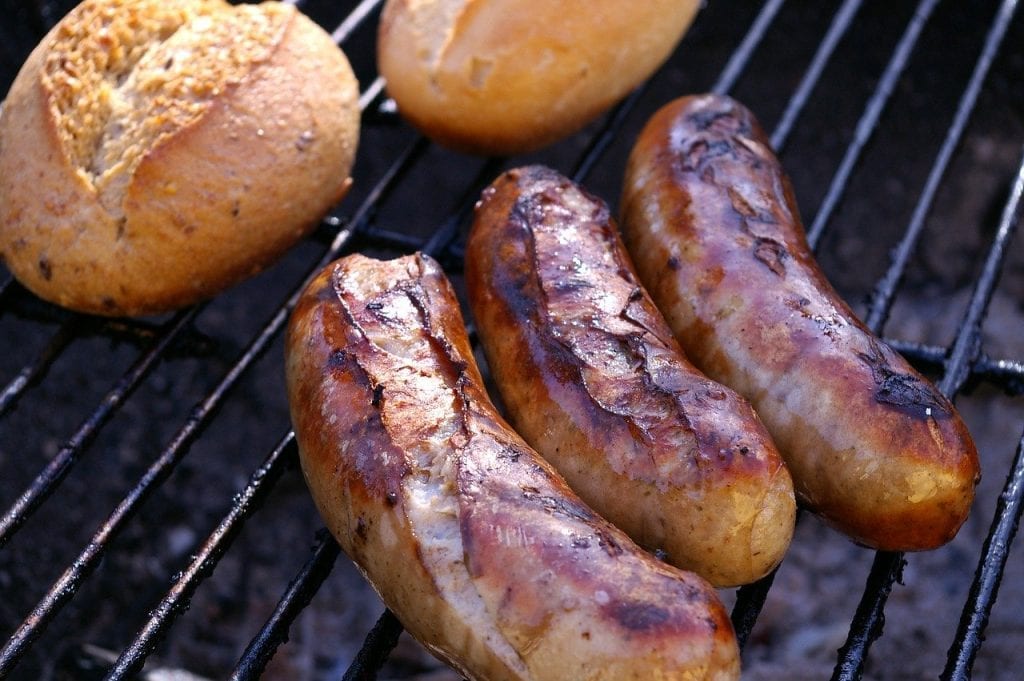 bratwursts on the grill with bread rolls