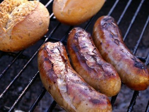 bratwursts on the grill with bread rolls