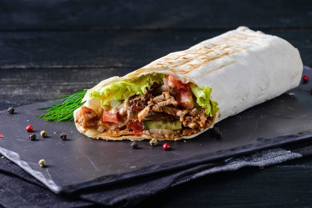 beef steak burrito filled with beans and various vegetables