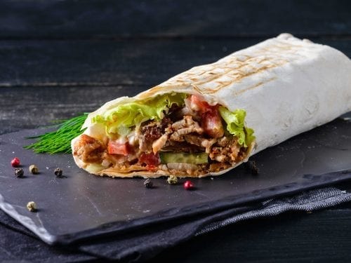 beef steak burrito filled with beans and various vegetables