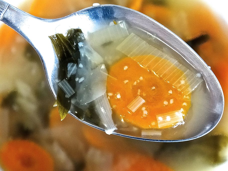 closeup on a spoonful of soup with vegetables