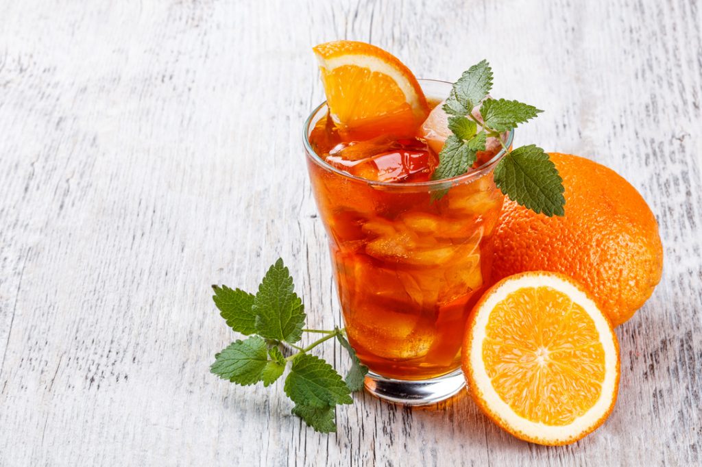 orange iced tea with orange fruit and mint