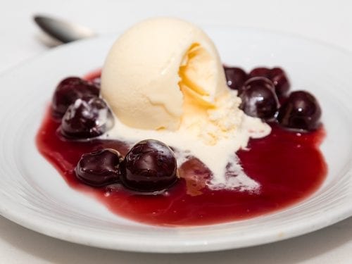 Cherries Jubilee Recipe, dessert with flambéed cherries topped with vanilla ice cream