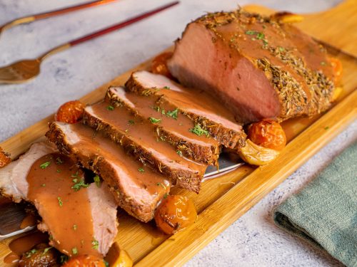 Christmas Beef Roast Recipe, Beef roast sliced and topped with port wine sauce and served on a long wooden board