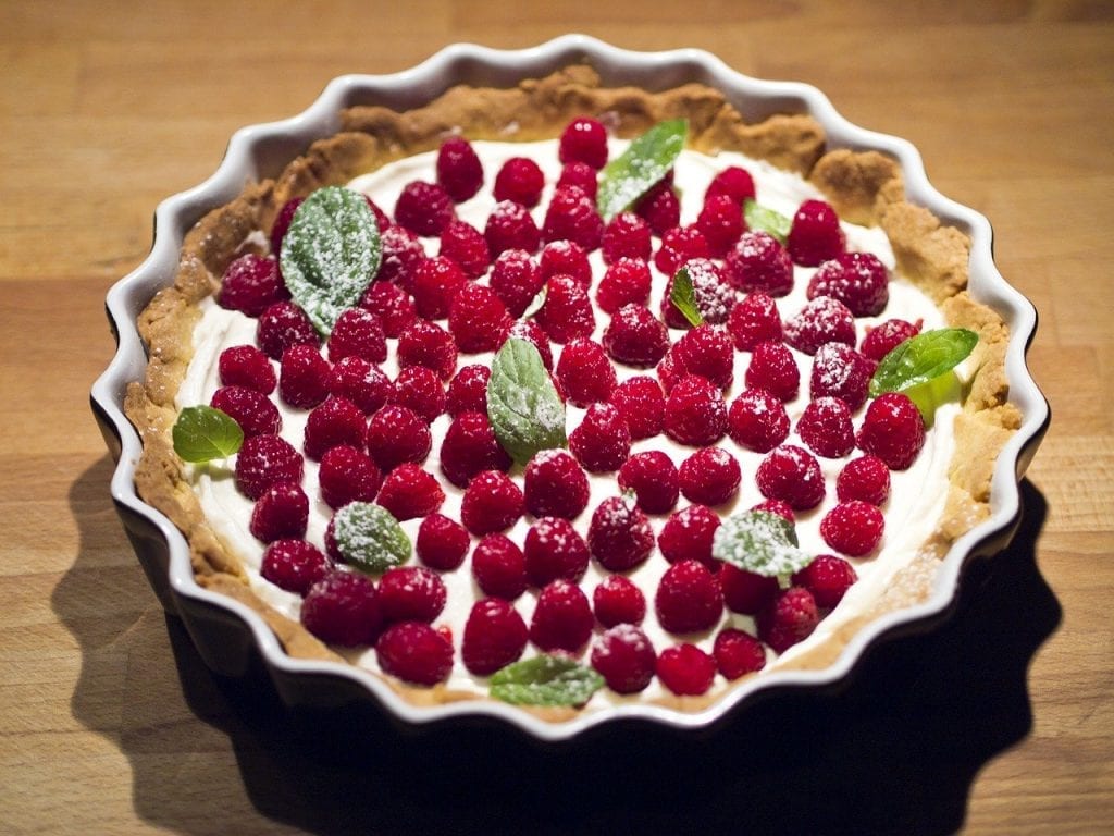 pie topped with whipped topping and raspberries