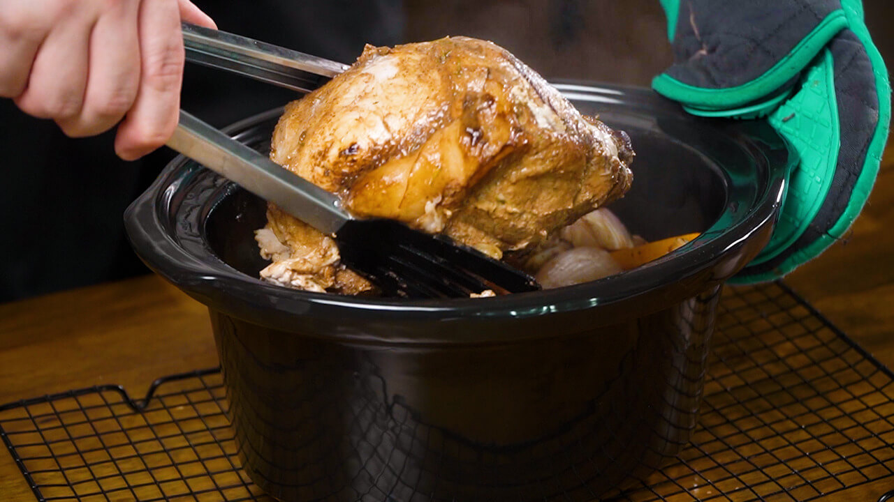 adding the potatoes, carrots, garlic, onions, and pork shoulder to the crockpot