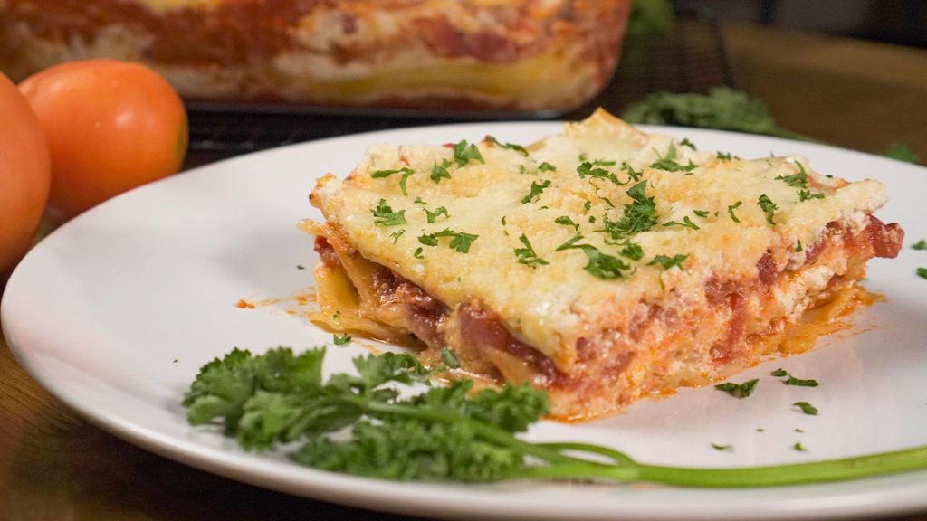 Olive Garden’s Lasagna Classico Recipe, Slice of lasagna topped with parsley and served on white plate