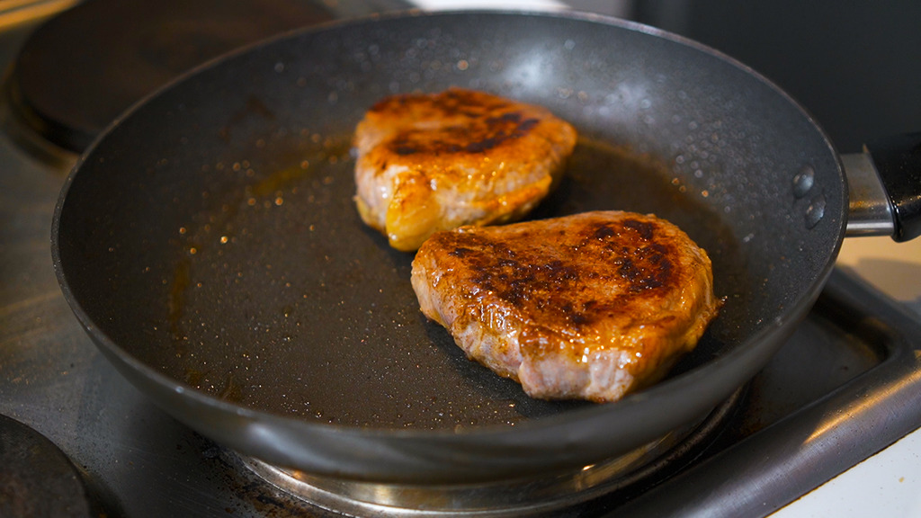searing eye of round steak in a heated skillet