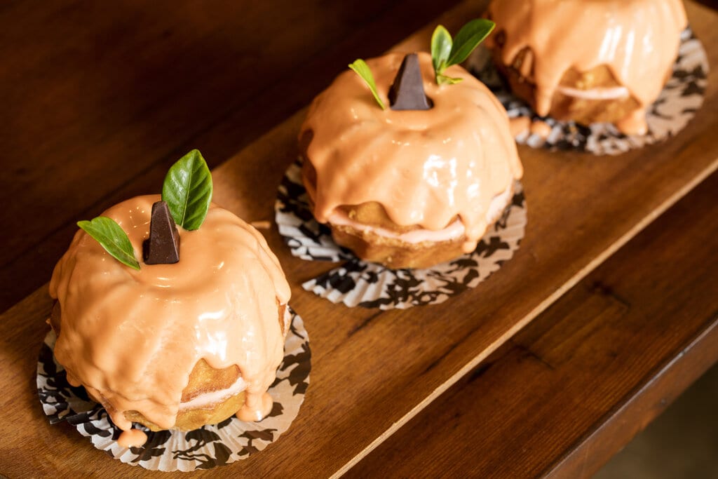 Jack-O-Lantern Pumpkin Bundt Cake Recipe, Mini pumpkin bundt cakes with vanilla frosting, topped with assorted chocolates