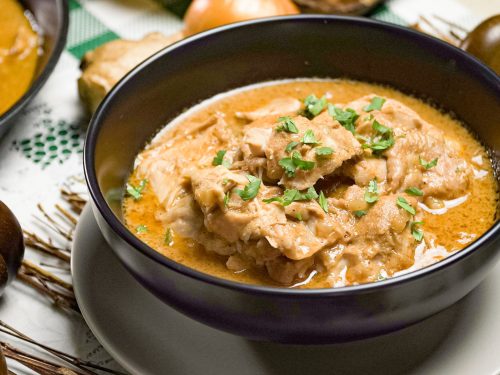 Slow Cooker Butter Chicken Recipe, Butter chicken with cilantro on top in a black bowl