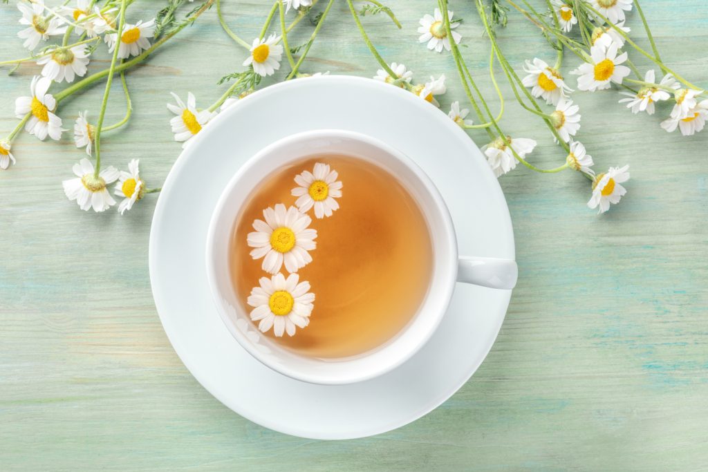 Chamomile tea benefits side effects and recipes, a cup of chamomile tea with chamomile flowers