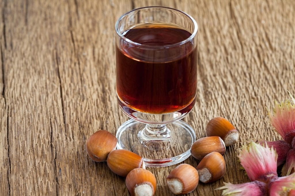 a glass of hazelnut liqueur with hazelnuts