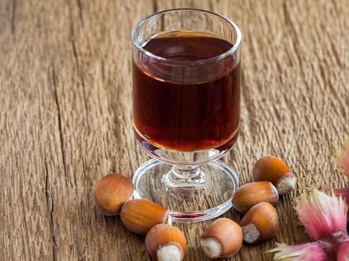 a glass of hazelnut liqueur with hazelnuts