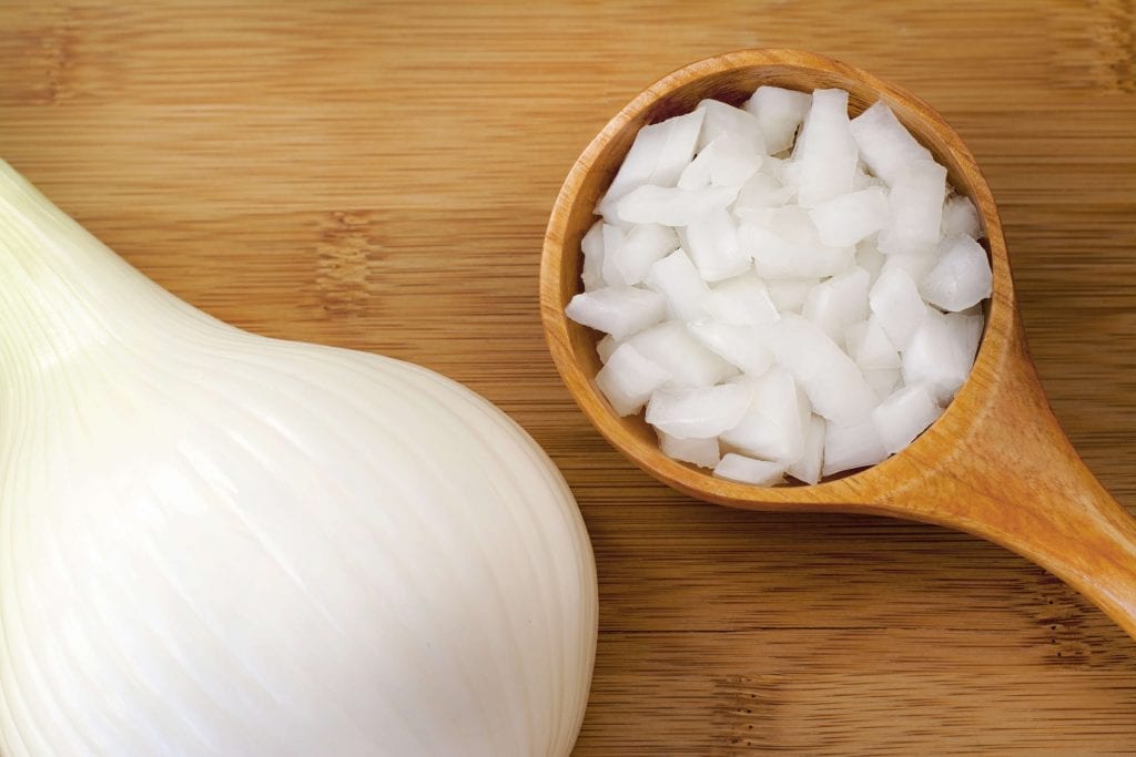 onion slices in a wooden spoon