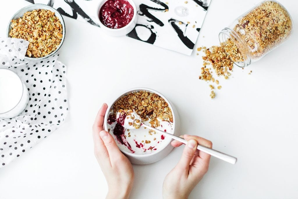 yogurt, yogurt in a bowl scooped with a spoon, yogurt with nuts and fruit preserves, eating yogurt