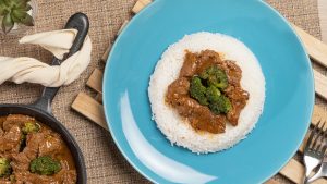 Broccoli Beef Stir Fry Recipe, Broccoli beef stir fry served on a bed of rice over a blue plate