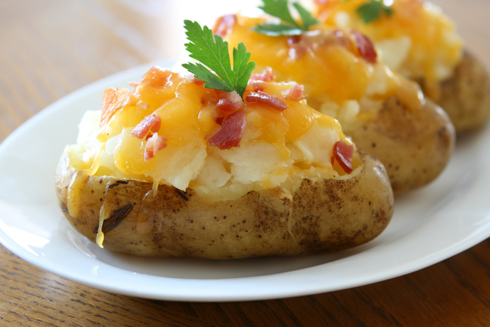 bacon cheese baked potatoes on a white plate