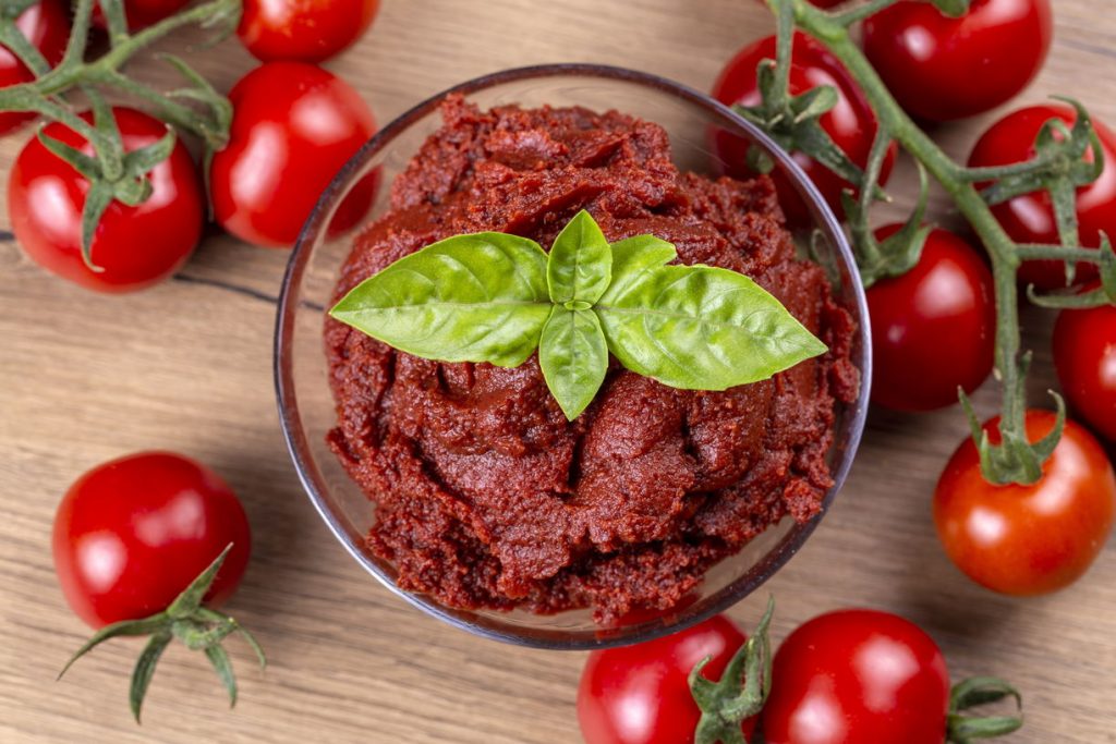 a bowl of tomato paste and fresh tomatoes