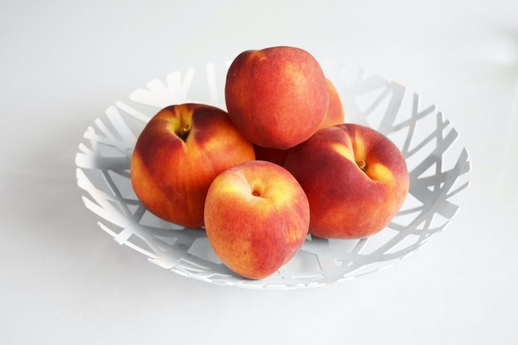 Apples on a minimalist white plastic fruit bowl
