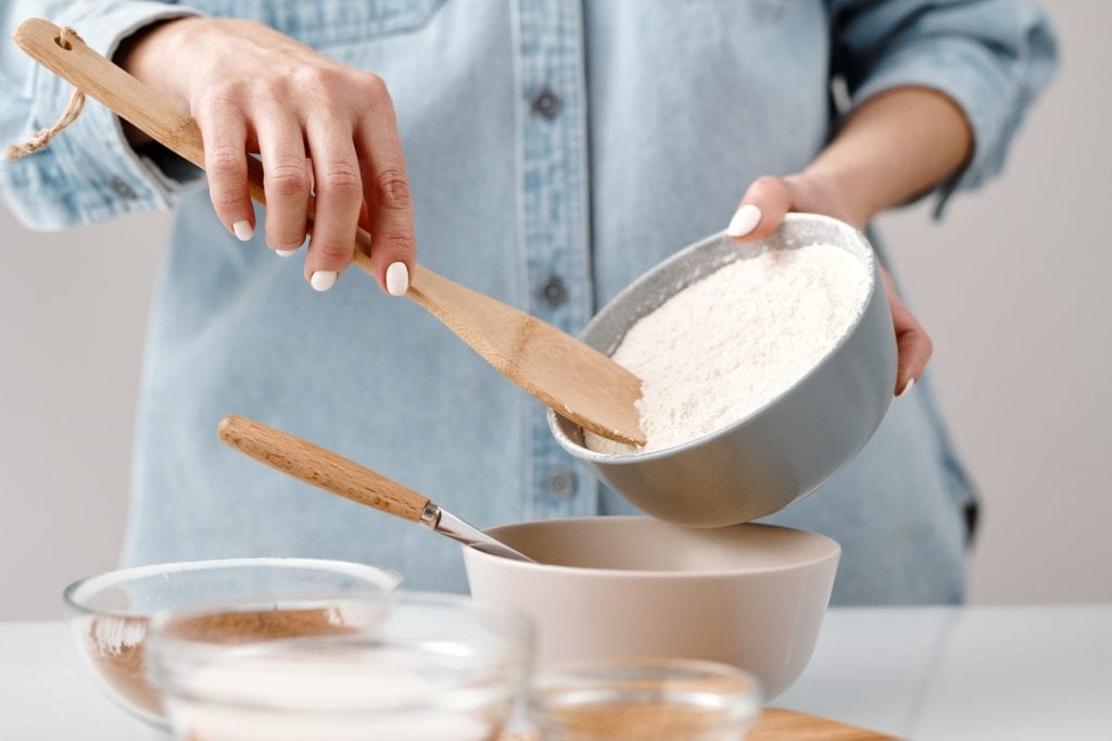Woman pouring high-gluten flour into a bowl