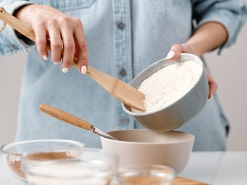 Woman pouring high-gluten flour into a bowl