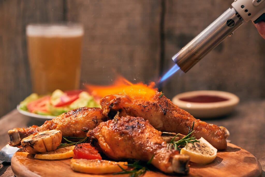 crispy fried chicken and a flaming kitchen torch