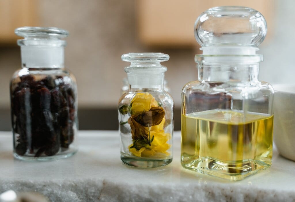 bottles of white wine vinegar, botanicals, and dried grapes