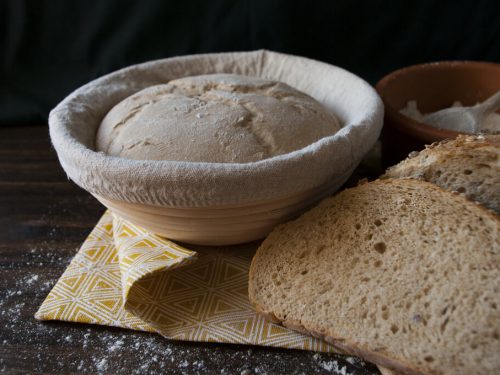 a proofing basket and a sourdough bread