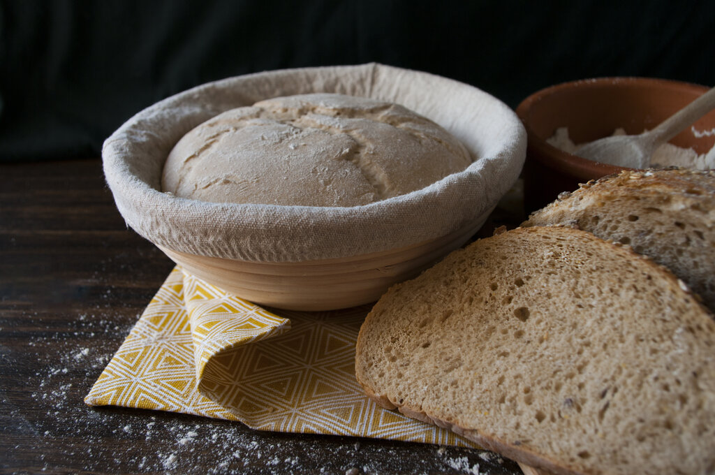 a proofing basket and a sourdough bread