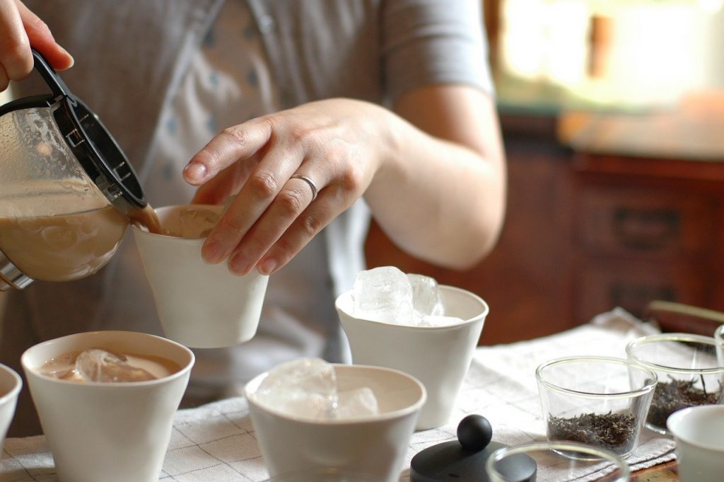Woman pouring chai tea, a coffee substitute with caffeine